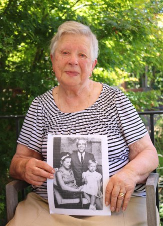 Photo of Tamara holding a photo of her as a child with her parents.